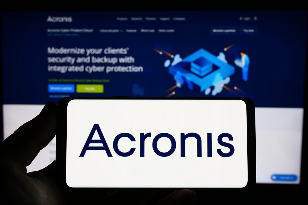 Stuttgart, Germany - 07-13-2023: Person holding smartphone with logo of technology company Acronis International GmbH on screen in front of website. Focus on phone display. Unmodified photo.